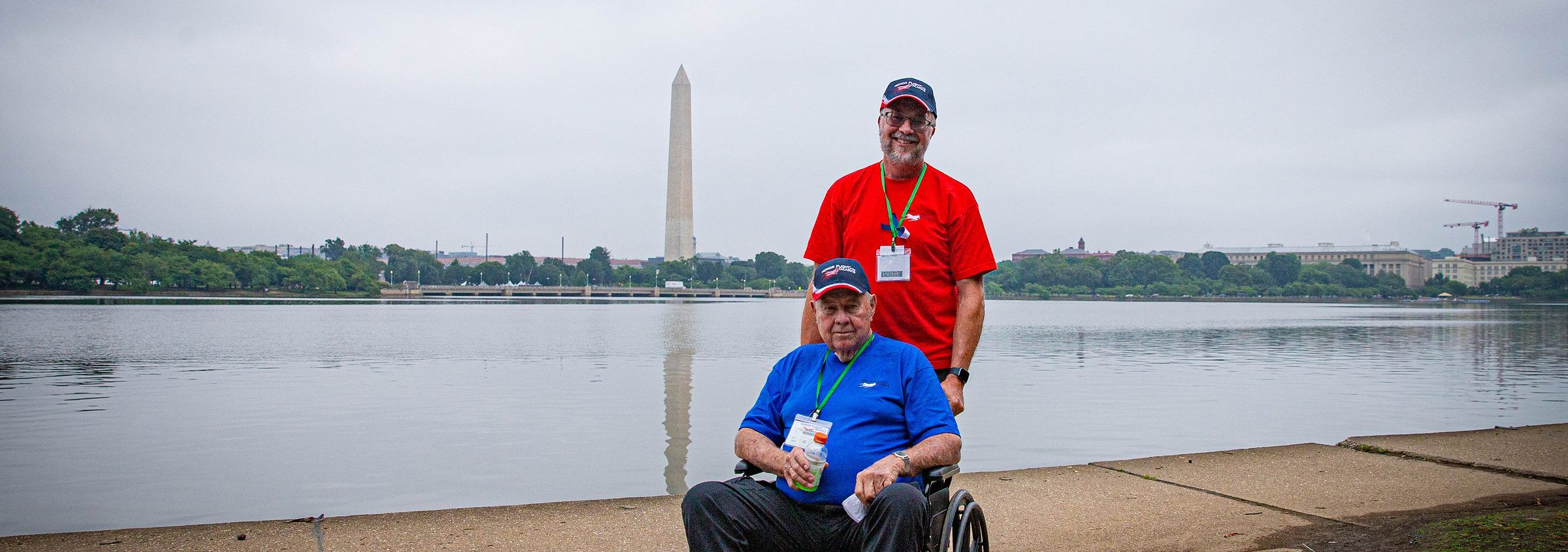 Veteran in a wheelchair with his Guardian across from the Washington Monument
