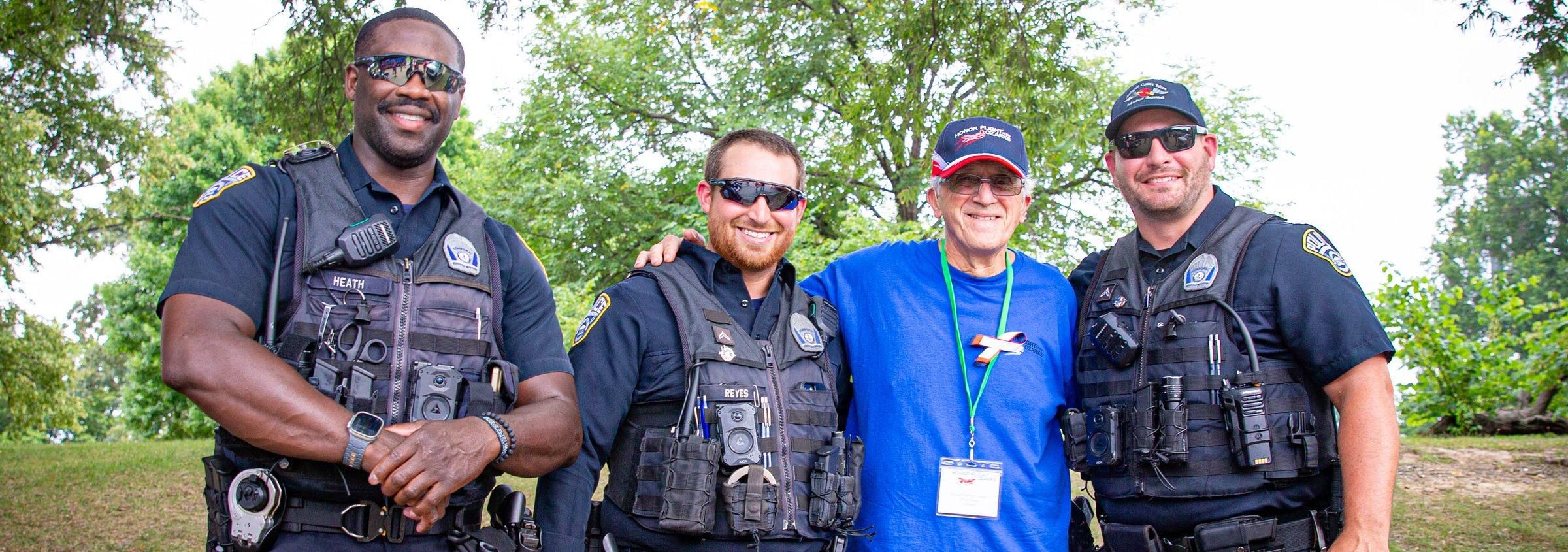 Honor Flight veteran posing with three police officers during his mission to Washington, D.C.