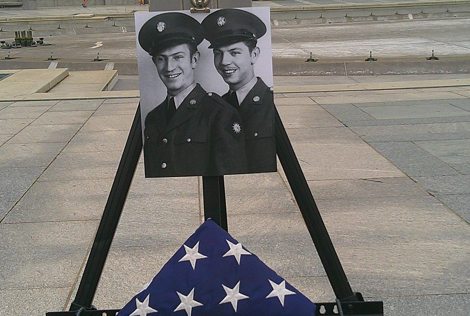 Easel holding a wartime portrait beside a folded flag at the World War II Memorial