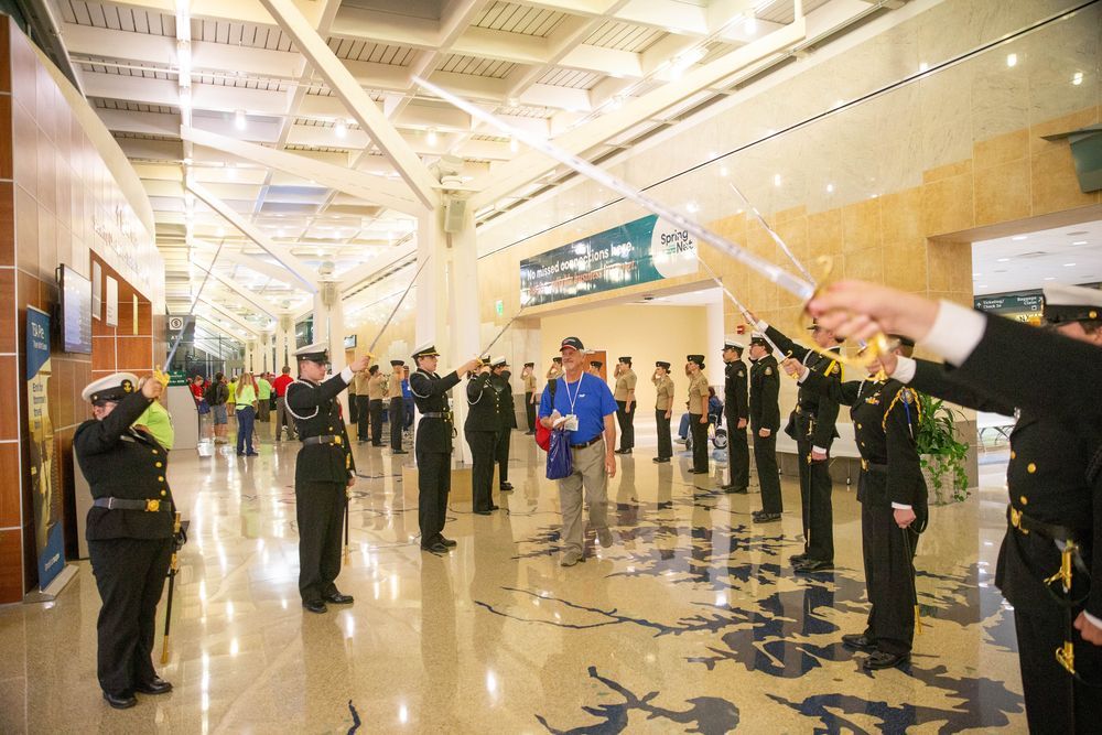Veteran walking through a sword arch salute at the airport