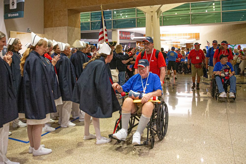 Veteran in a wheelchair welcomed home through a line of applauding volunteers