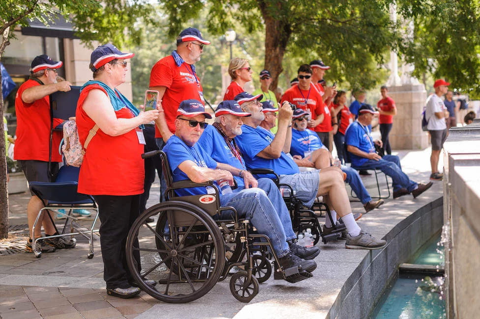 Honor Flight Veterans lined up sitting with Guardians behind them
